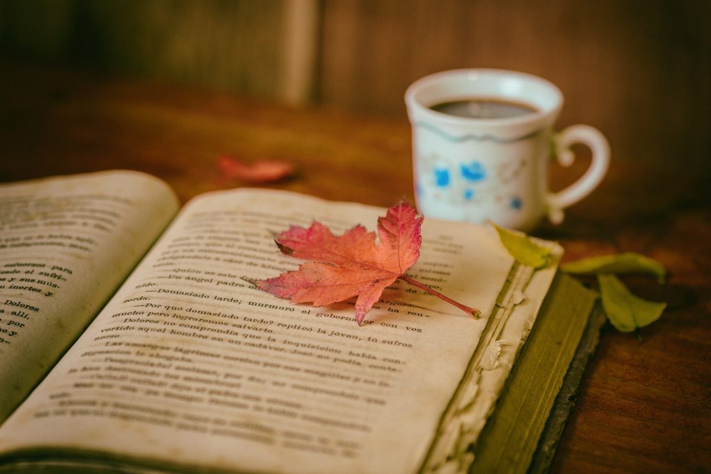 Afbeelding van een boek, een kop koffie en een blaadje.
